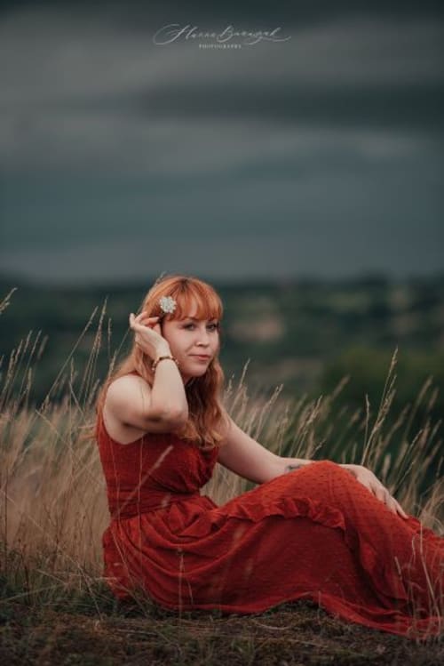 /_vercel/image?url=/Red+hair+woman+in+red+dress+is+sitting+in+the+high+grass+during+summer.&w=1536&q=100
